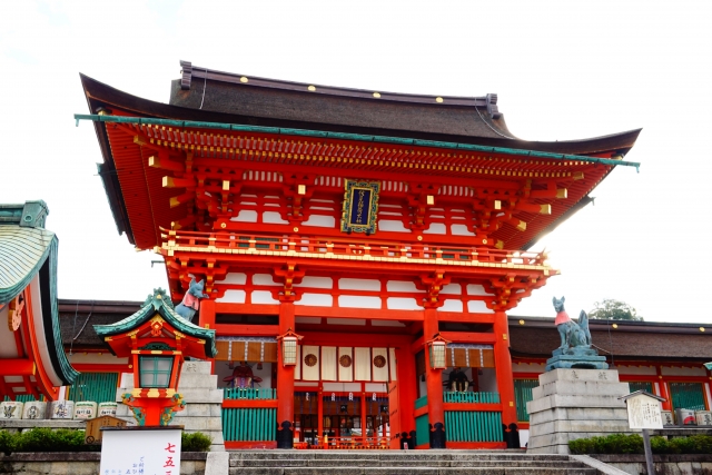 Fushimi Inari shrine entrance with red architecture and fox guardians