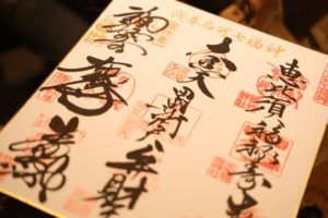 Page of Japanese goshuin temple and shrine stamps with calligraphy and red seals